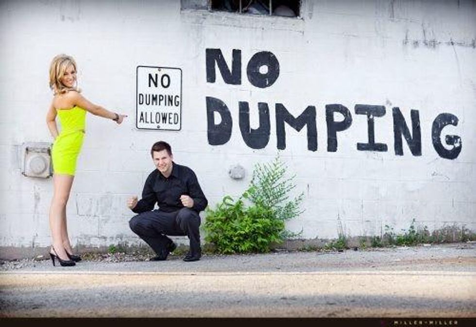 A couple poses awkwardly for an engagement photo