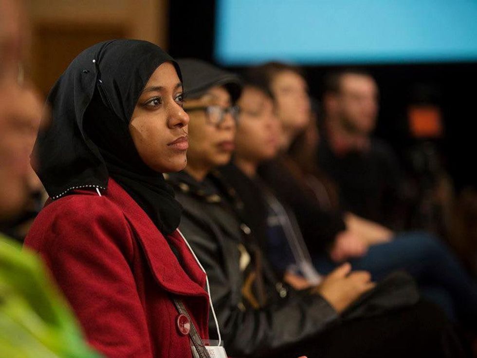 A diverse crowd listens to a panel on race.