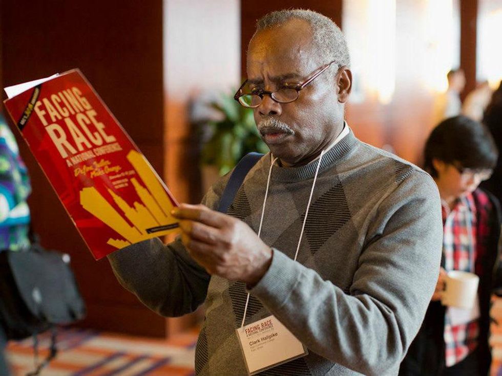 A man reads a Facing Race program
