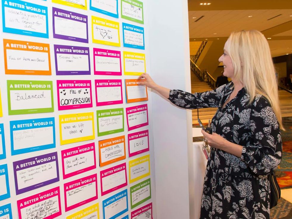 An attendee participates in the A Better World Is wall