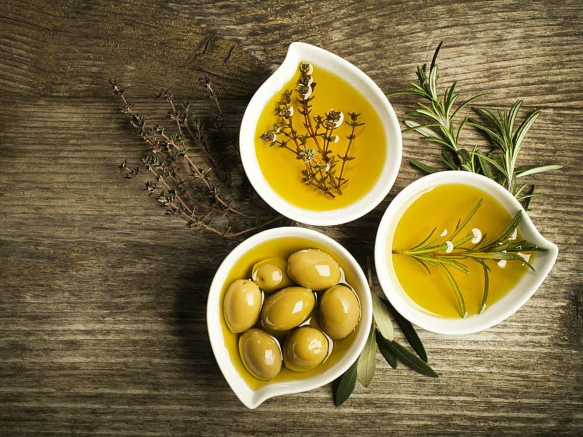 Bowls of olives, olive oil, and herbs