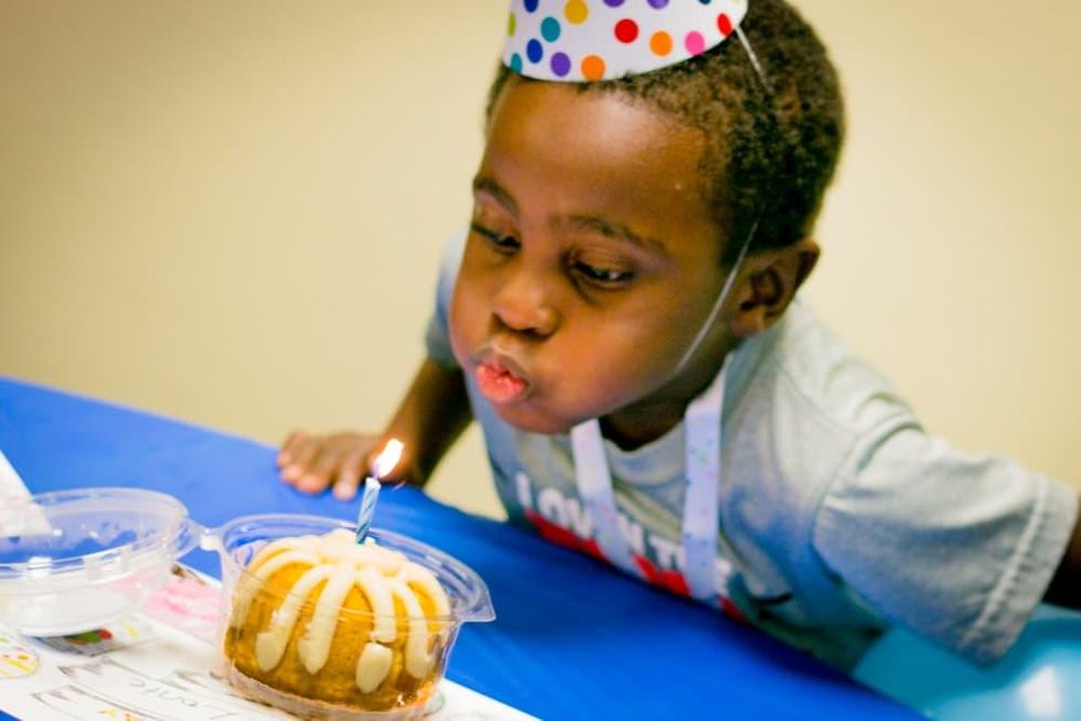 Boy blowing out candle courtesy of Dallas' Birthday Party Project