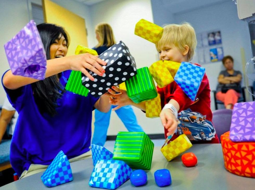 Bridget Le of Volunteer Services helped 8-year-old CCBD patient Cameron Davis with some constructive destruction