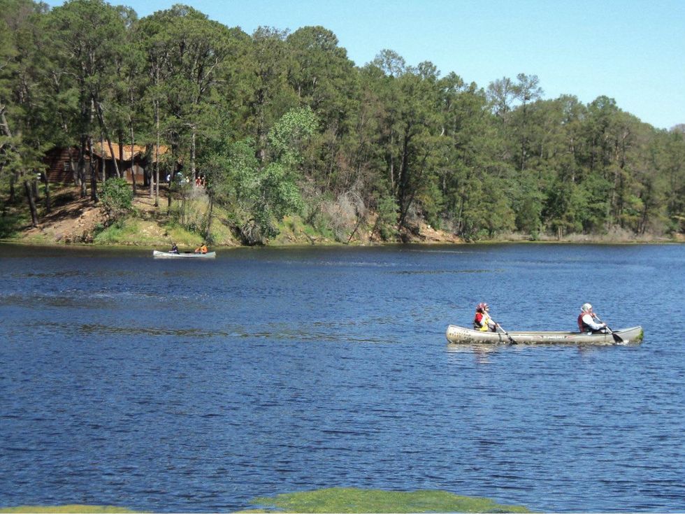 canoeing in Bastrop State Park with cabin in back