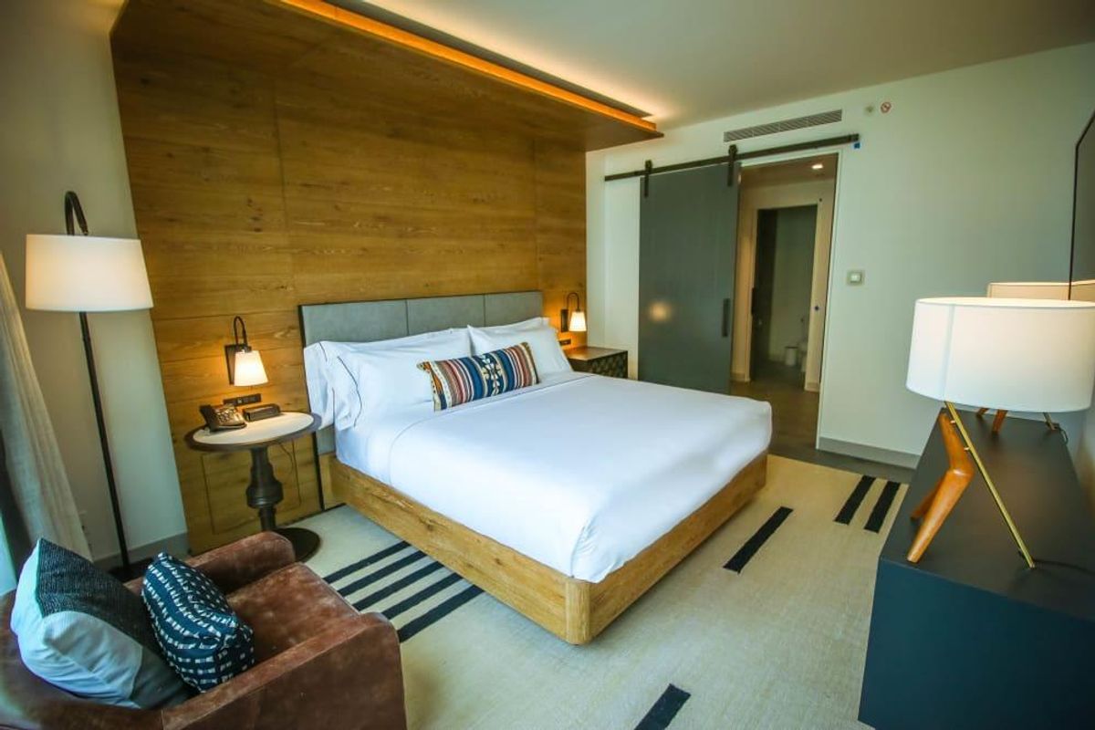 Guest rooms include beds with the brand's signature overhanging