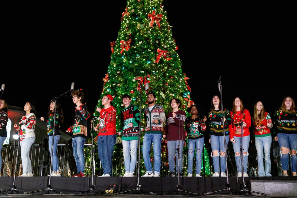 Carolers in front of Christmas tree