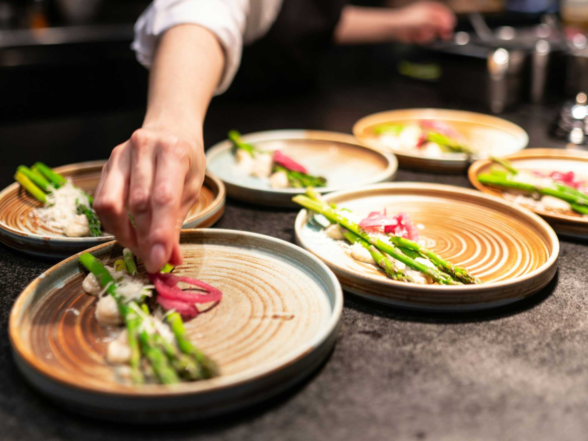Chef preparing multiple plates at a restaurant