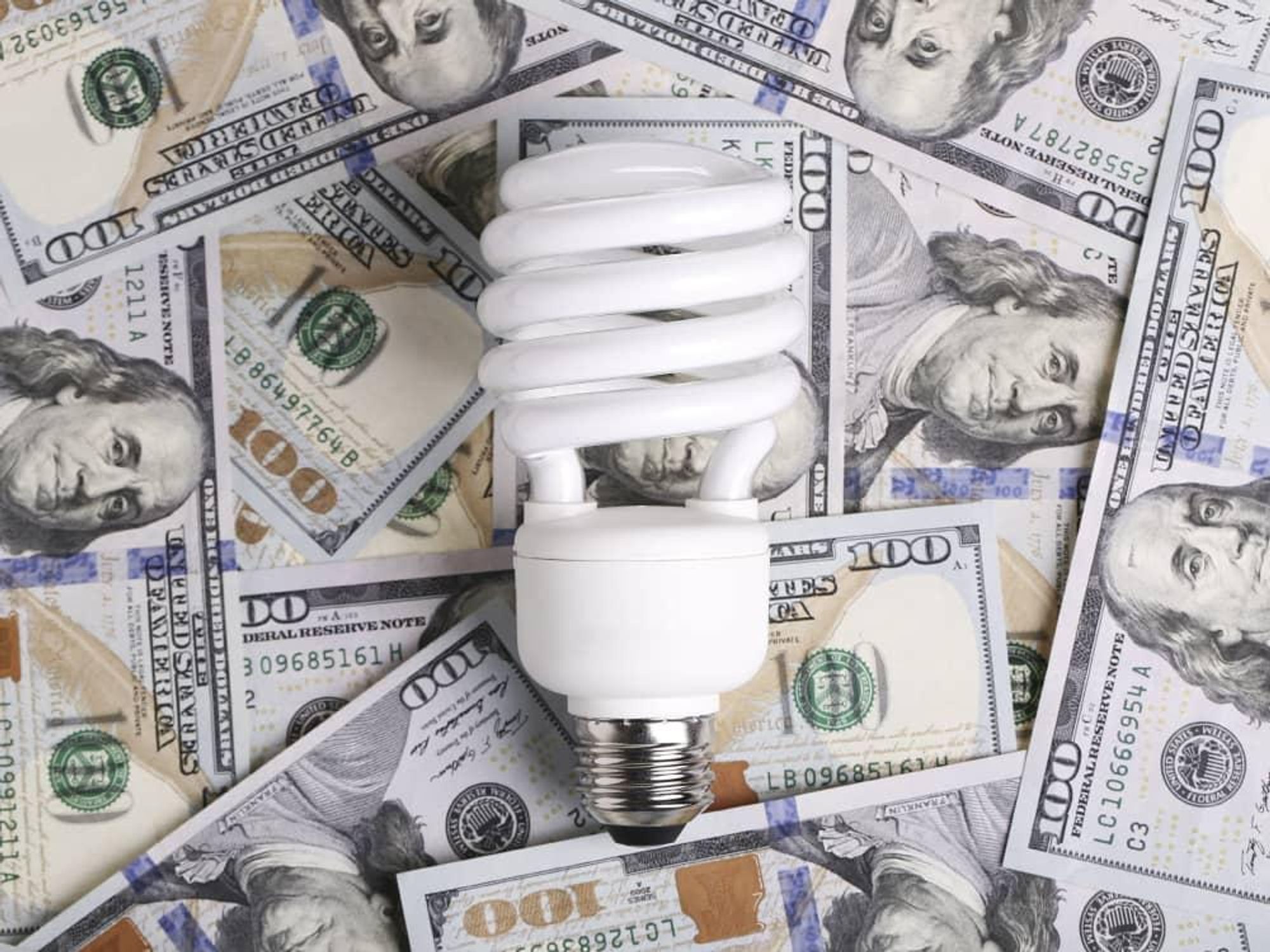 Compact fluorescent light bulb on a pile of cash