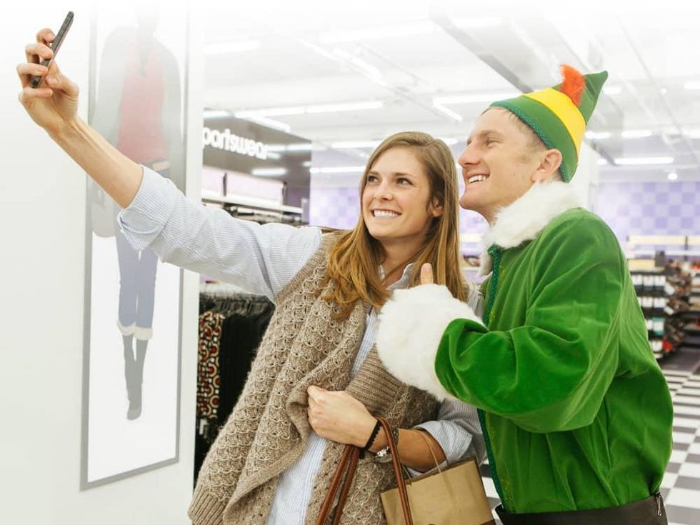 Elf posing with shopper for selfie