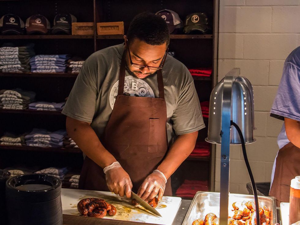 Employee slicing sausage at Pecan Lodge