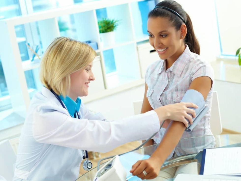 Female doctor and patient checking blood pressure