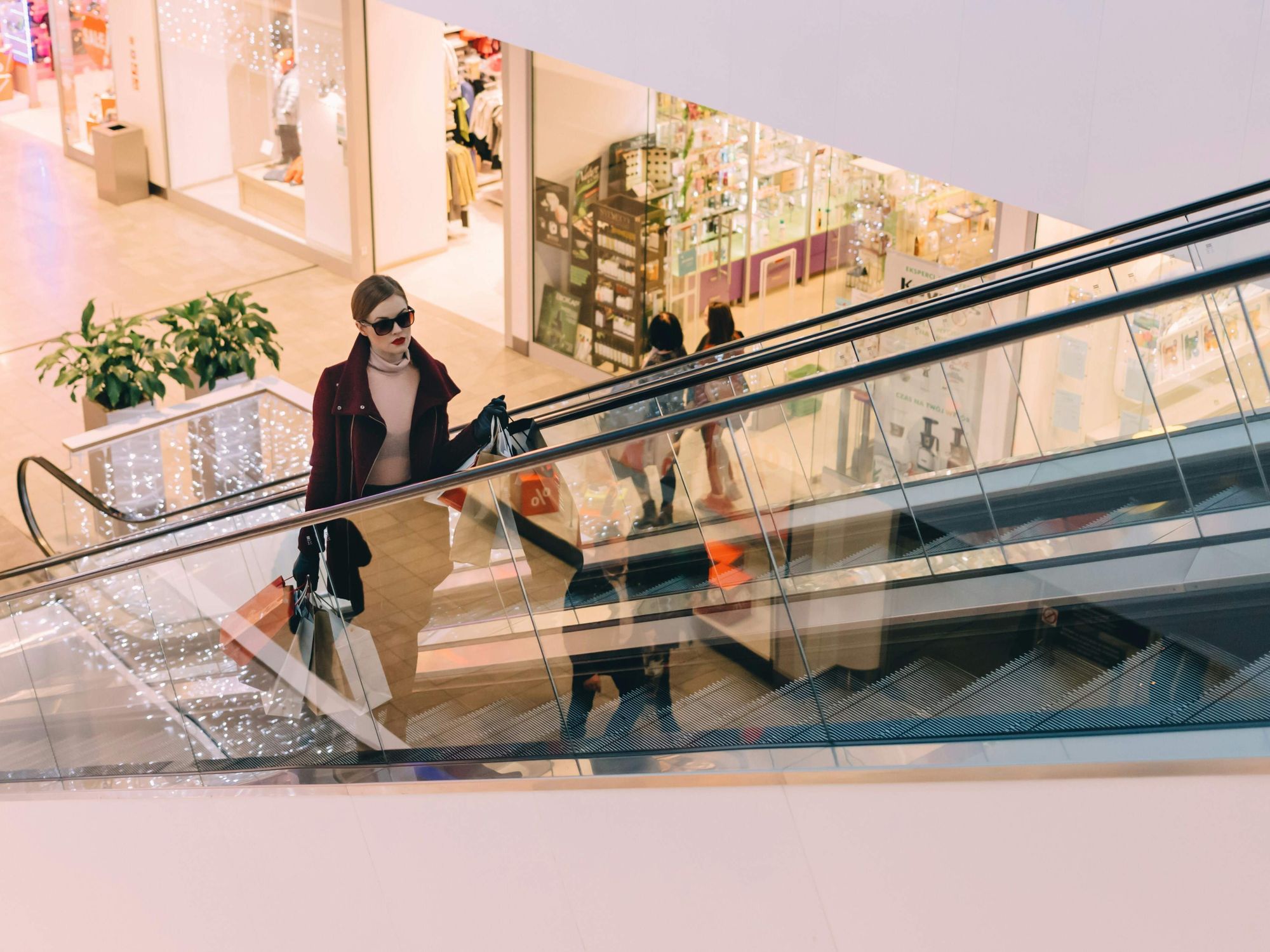 Female shopper, mall, escalator.
