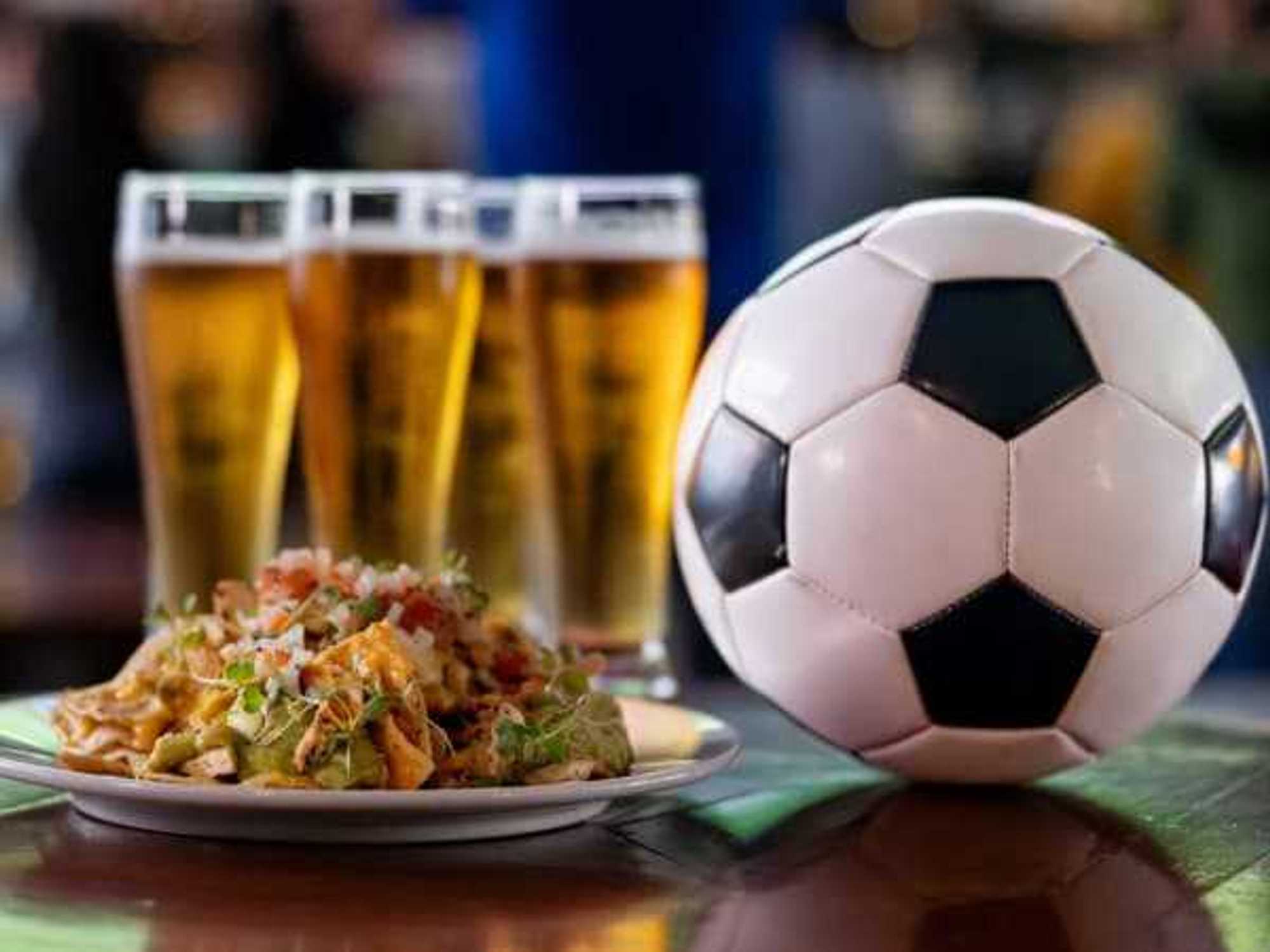 Food and drinks at a sports bar showing a football match