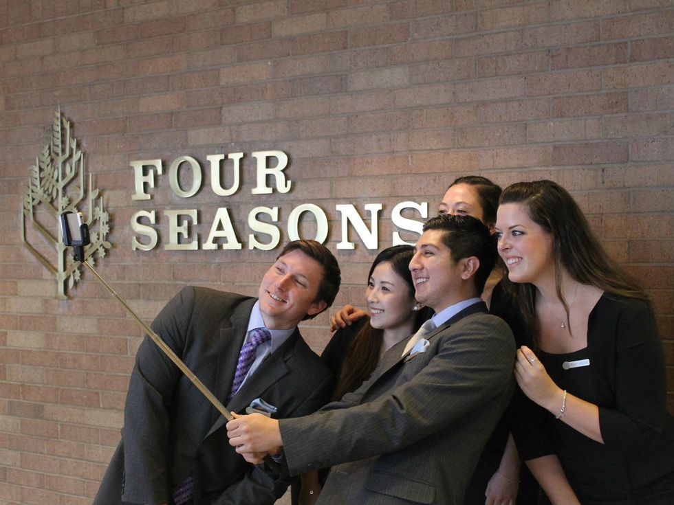 Four Seasons Hotel staff member demonstrate proper use of a Selfie Stick