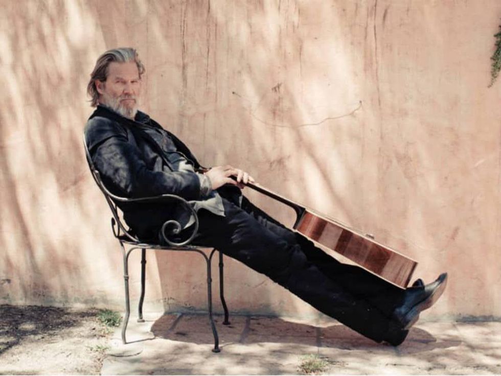 Jeff Bridges sitting in chair with guitar