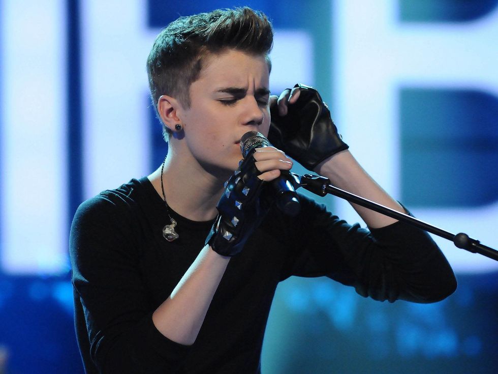 Justin Bieber, at mic, singing, black shirt