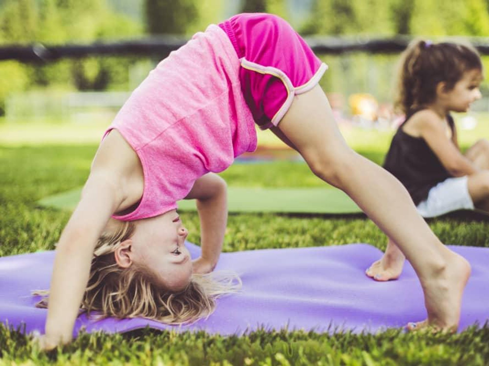 Kids doing yoga in a park