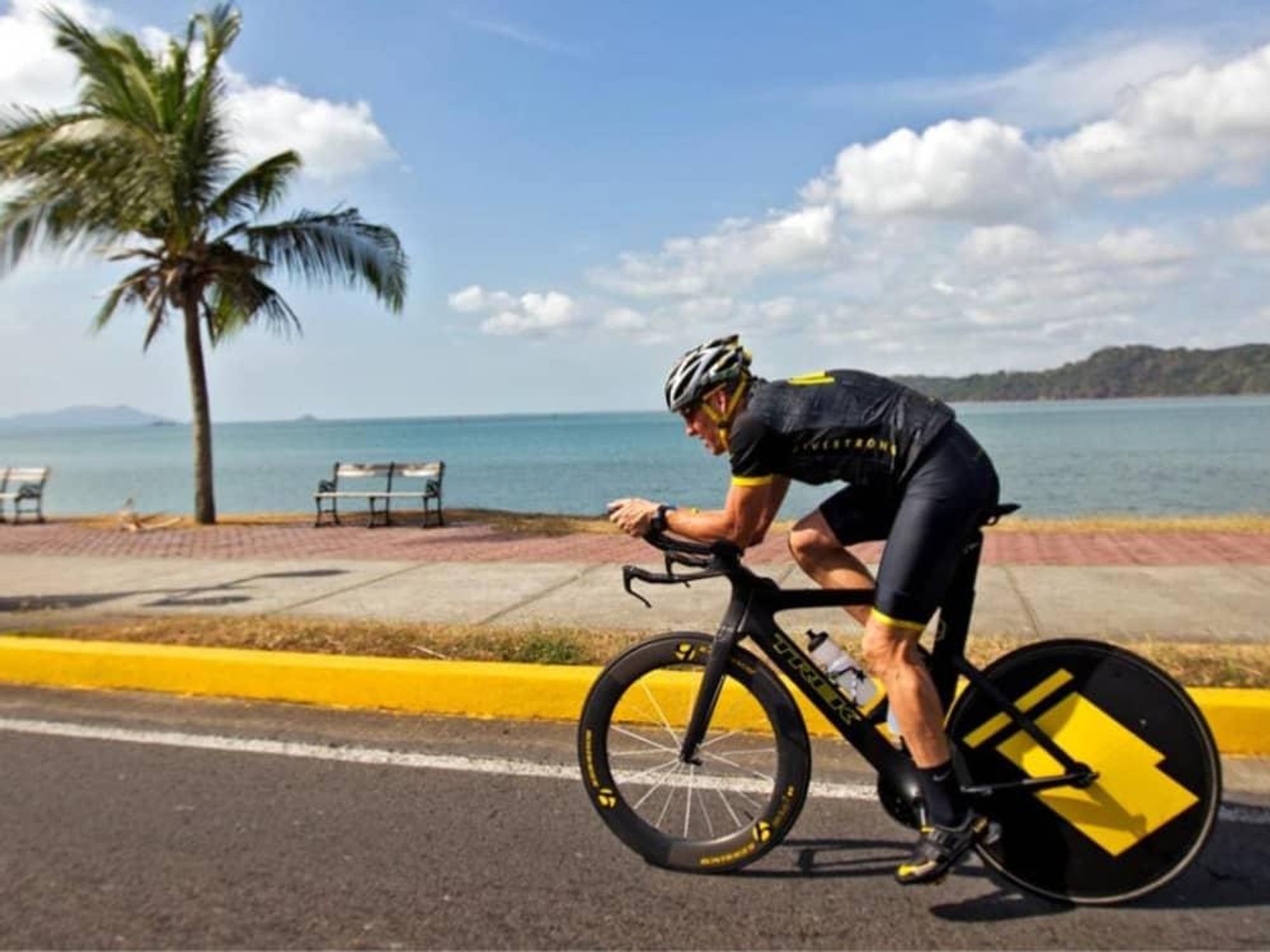 Lance Armstrong riding his bike along the beach