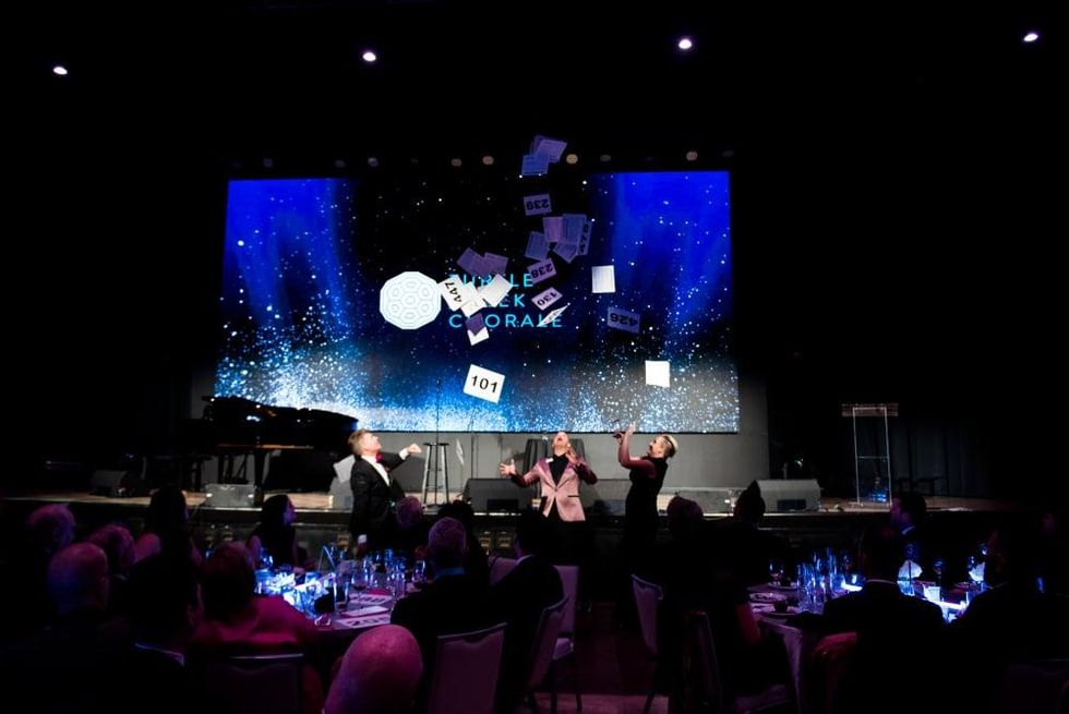 Mack Campbell, TCC board member and live auction chair, attempts to catch one paddle to win two meet-n-greet tickets for Idina Menzel.