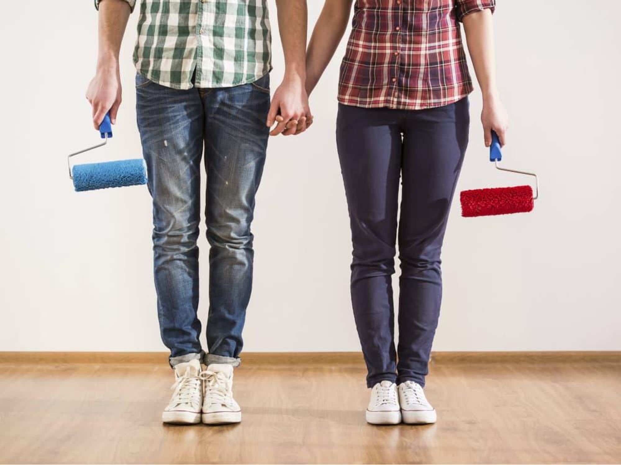 Man and woman holding paint brushes