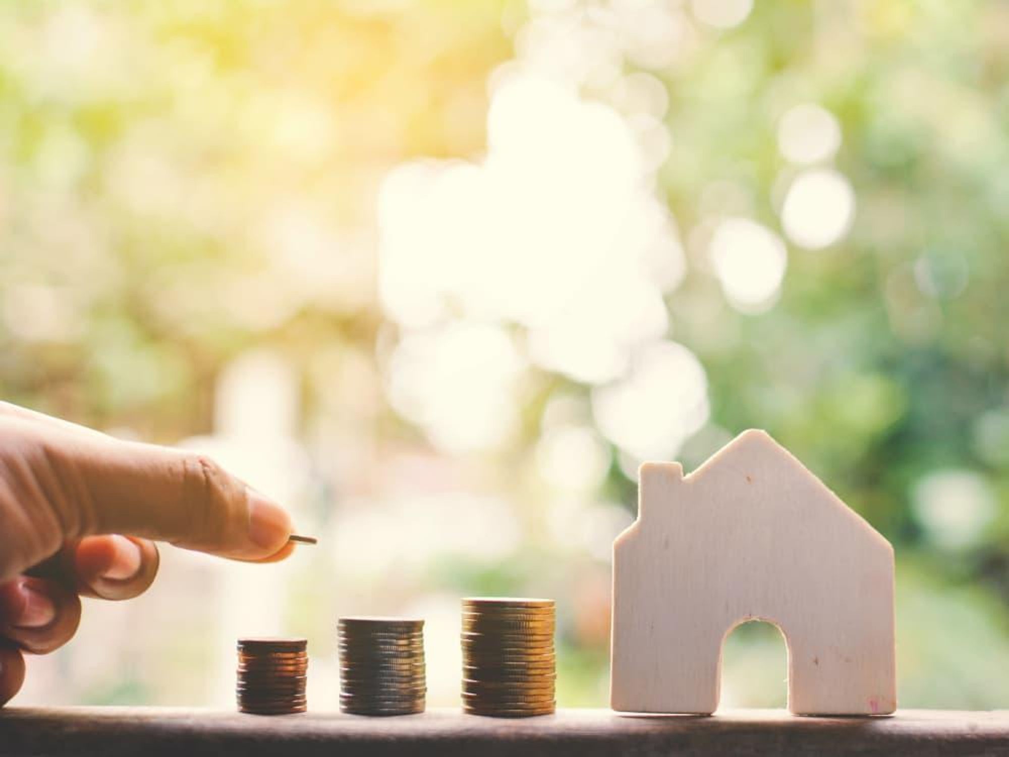 Money stacked next to a house