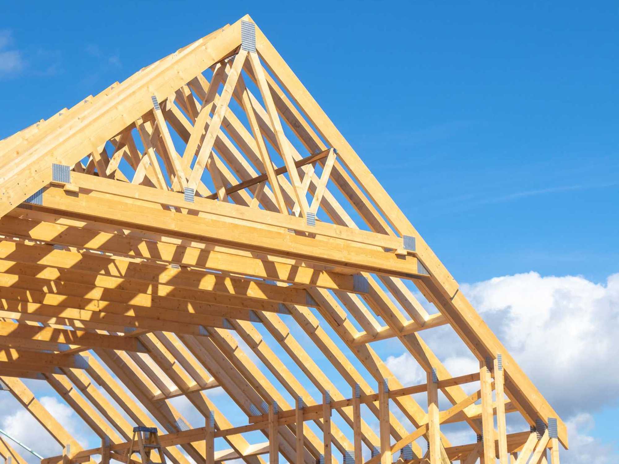 New residential construction home framing against a blue sky