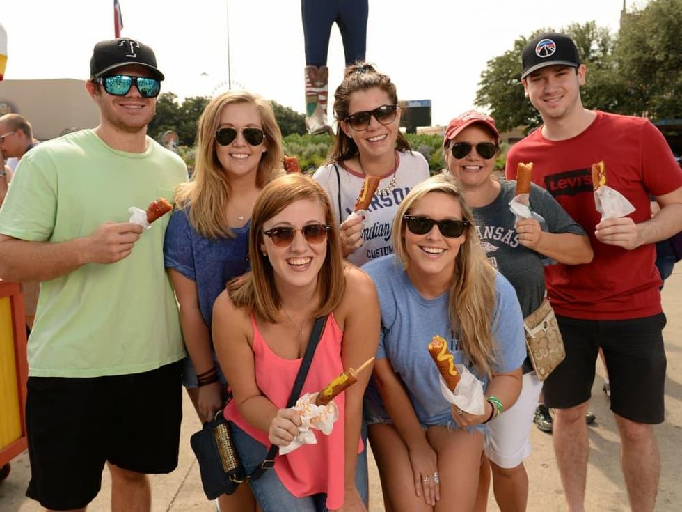 People eating corn dogs at State Fair of Texas