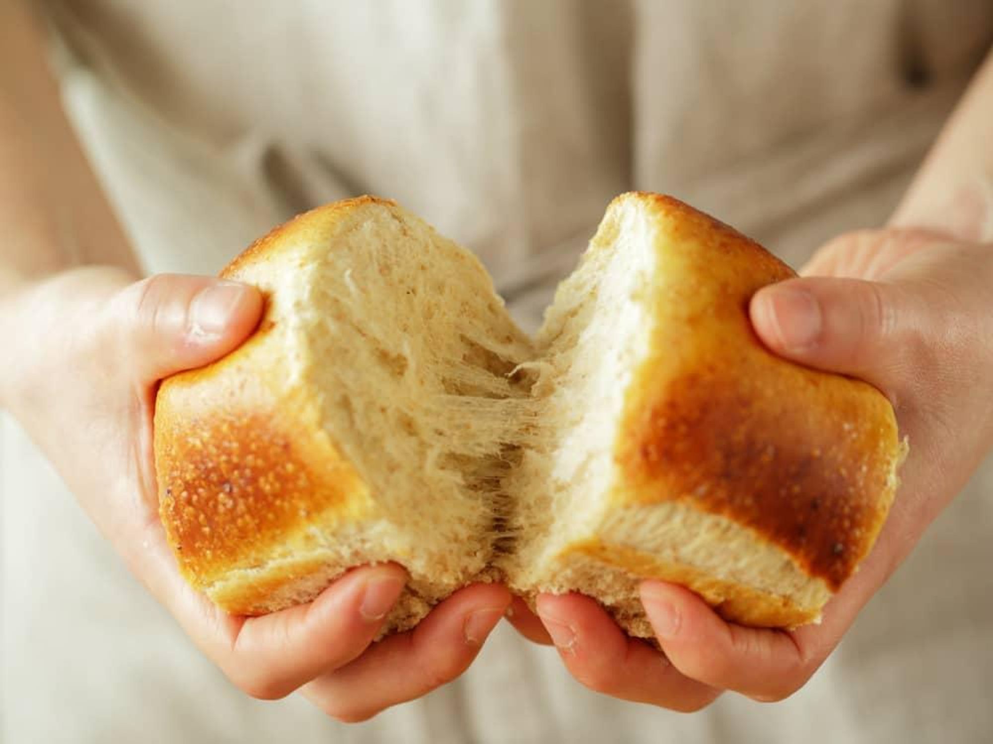 Person breaking apart bread