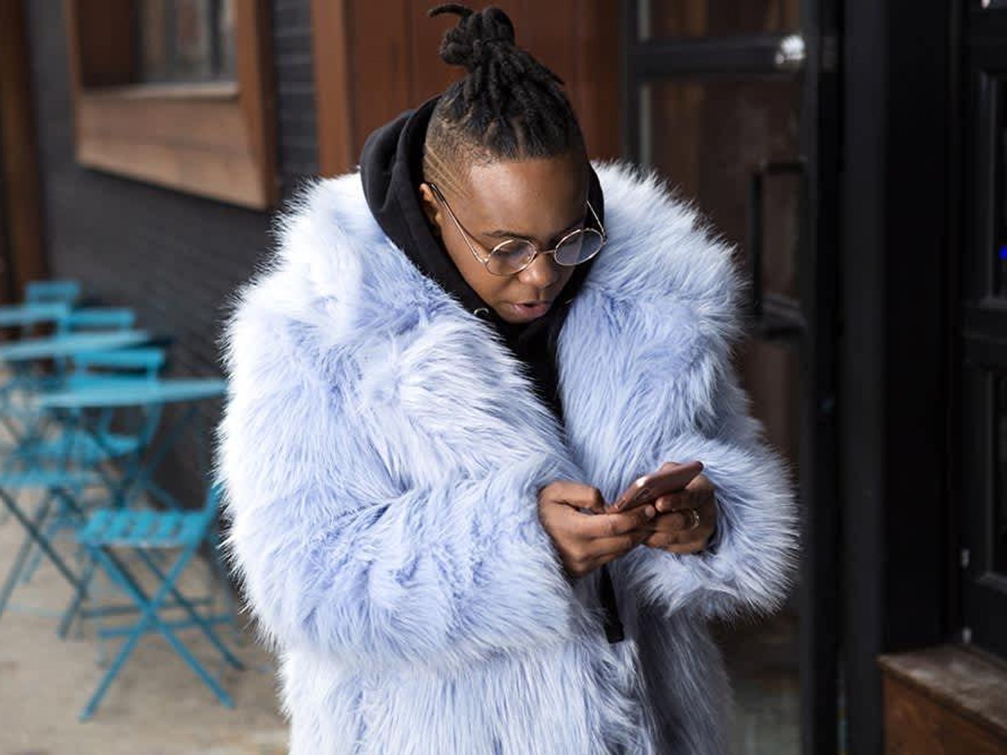 Person in fur coat looking at phone