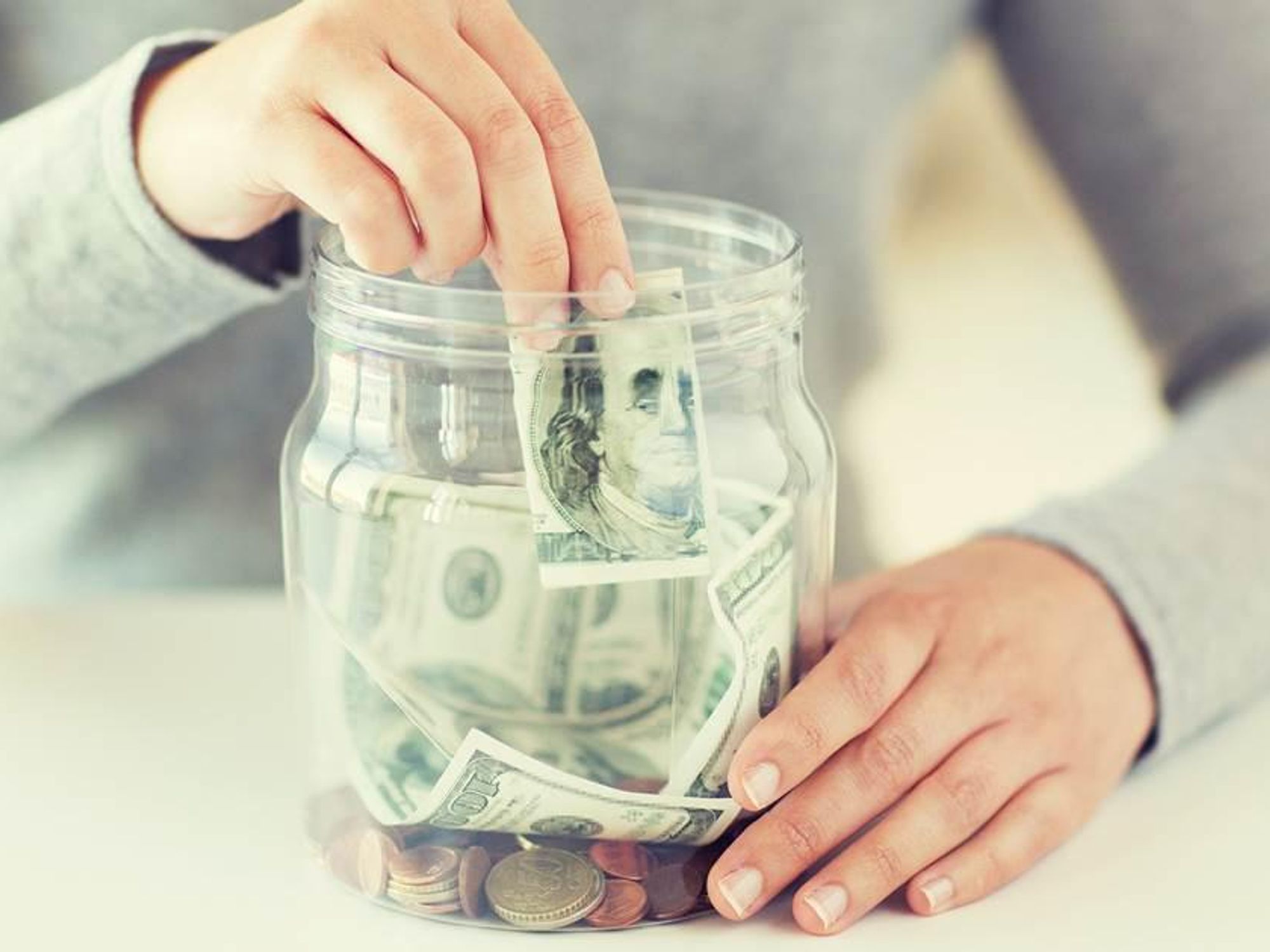 Person putting money in a jar