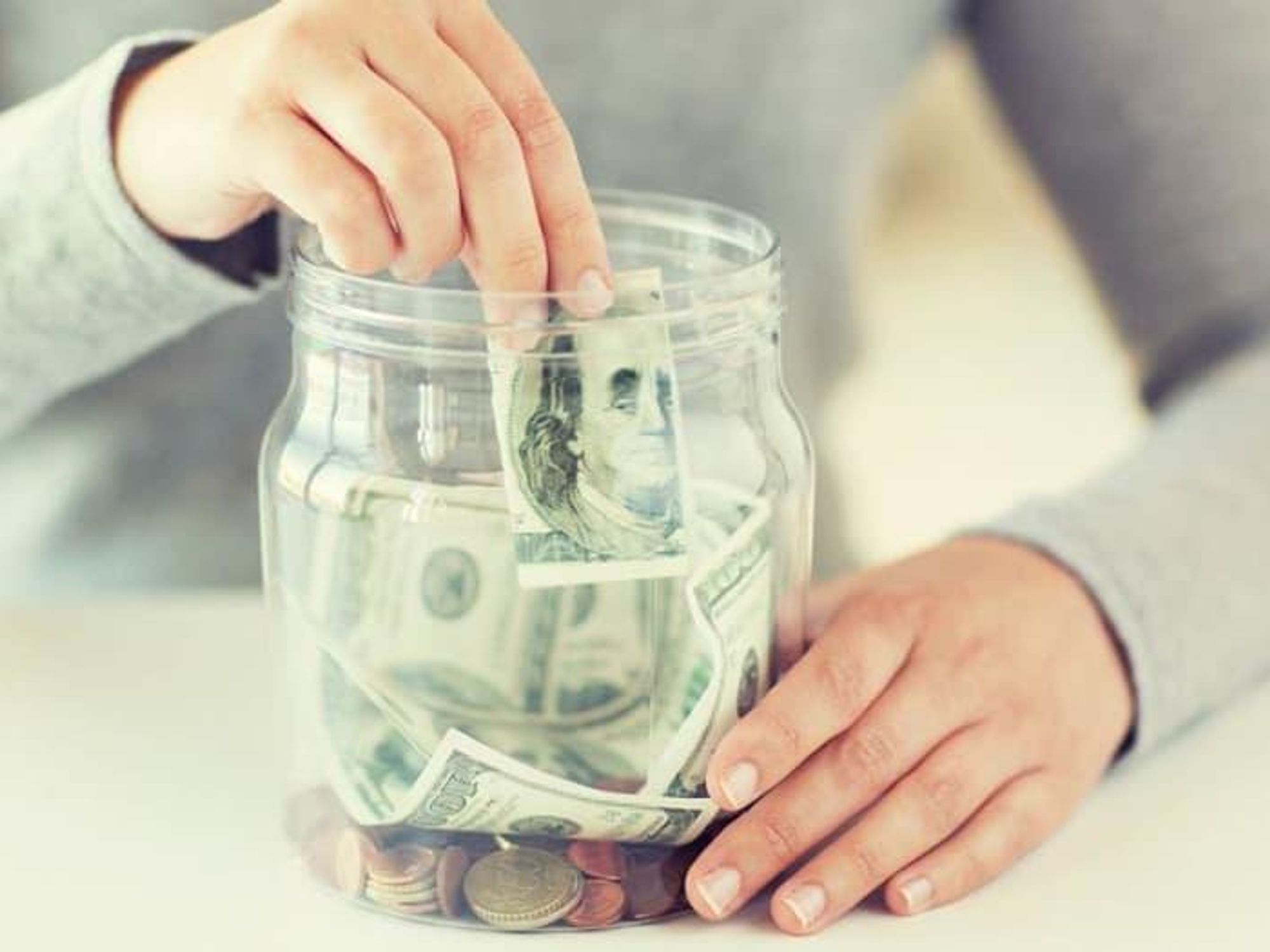 Person putting money in a jar