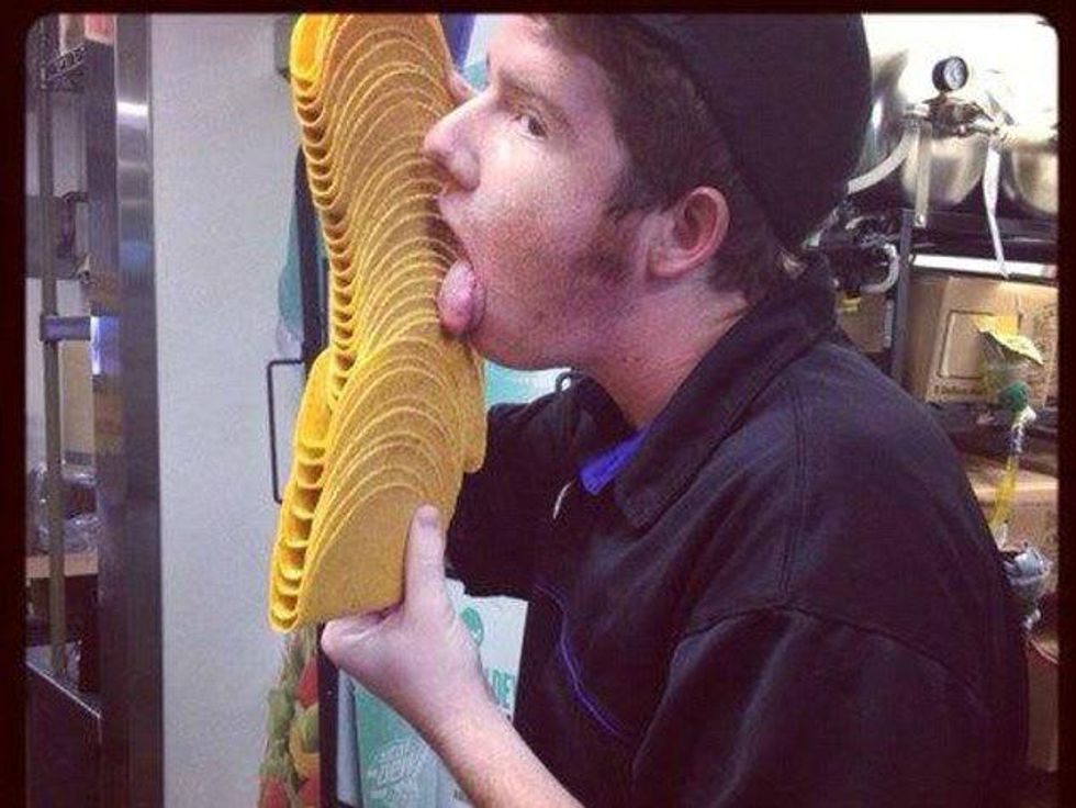 Taco Bell employee licks a tray of shells