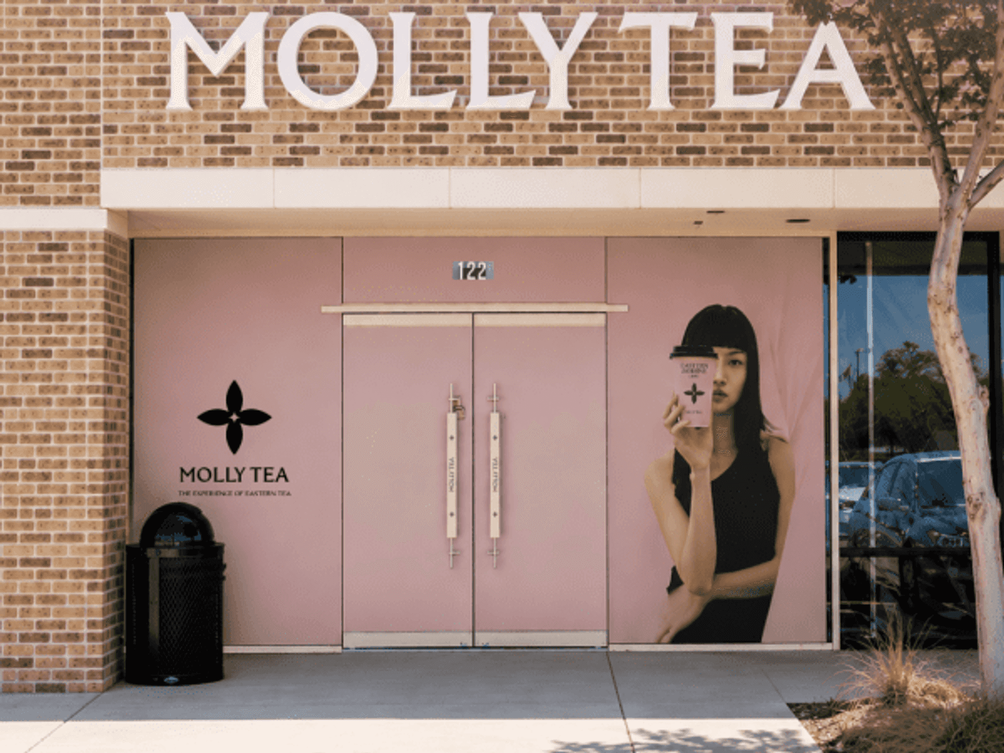 The sleek, pastel-pink storefront of Molly Tea’s new shop in Carrollton features its signature modern aesthetic.