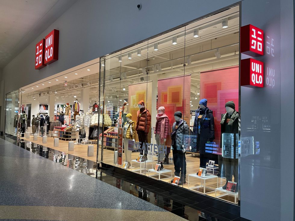 Window of Uniqlo's Topenga Mall location in California, showing mannequins in puffer jackets and hats.