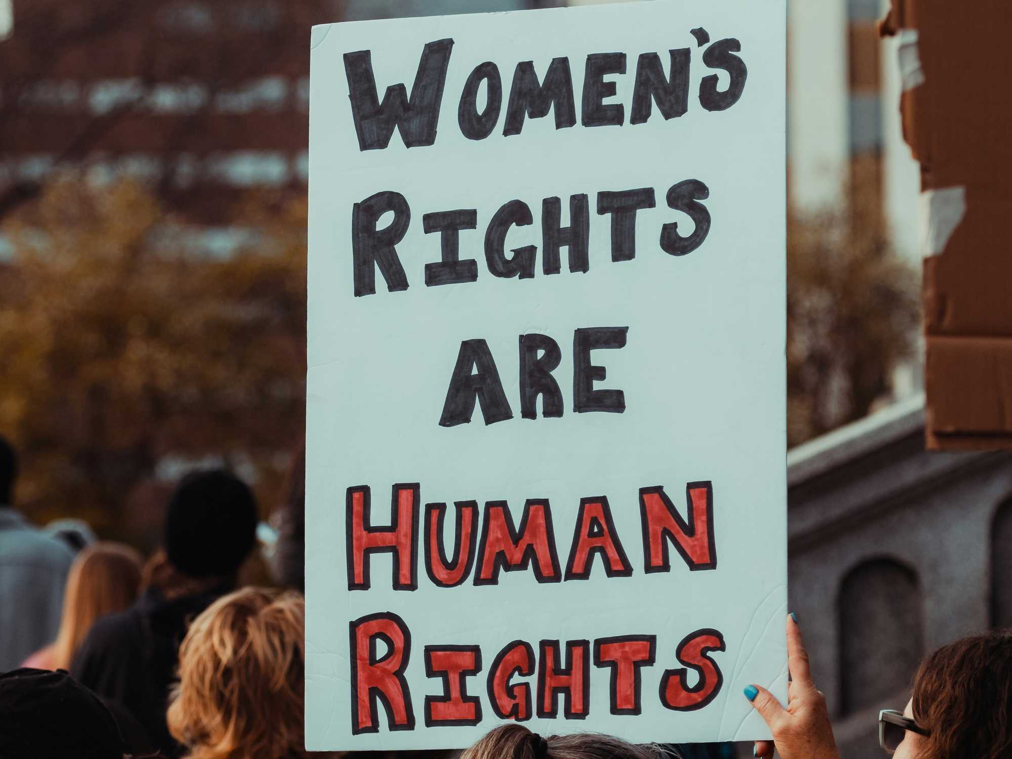 Woman holding a sign at a protest that states, "Women's rights are human rights"