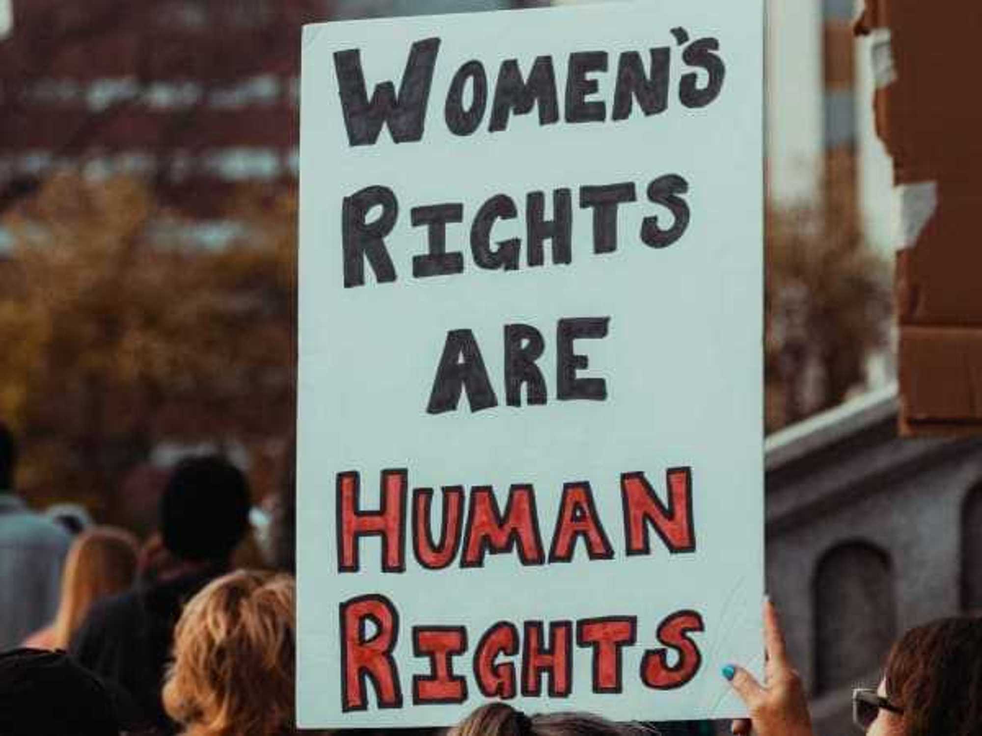 Woman holding a sign at a protest that states, "Women's rights are human rights"
