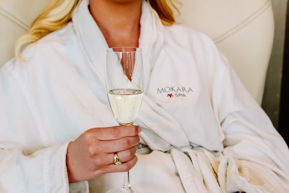 Women in Mokara Spa robe holding champagne